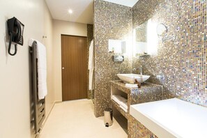 A bathroom with a mosaic tile wall, a sink, a mirror, and a towel rack. - Hotel Marotte (Amiens)