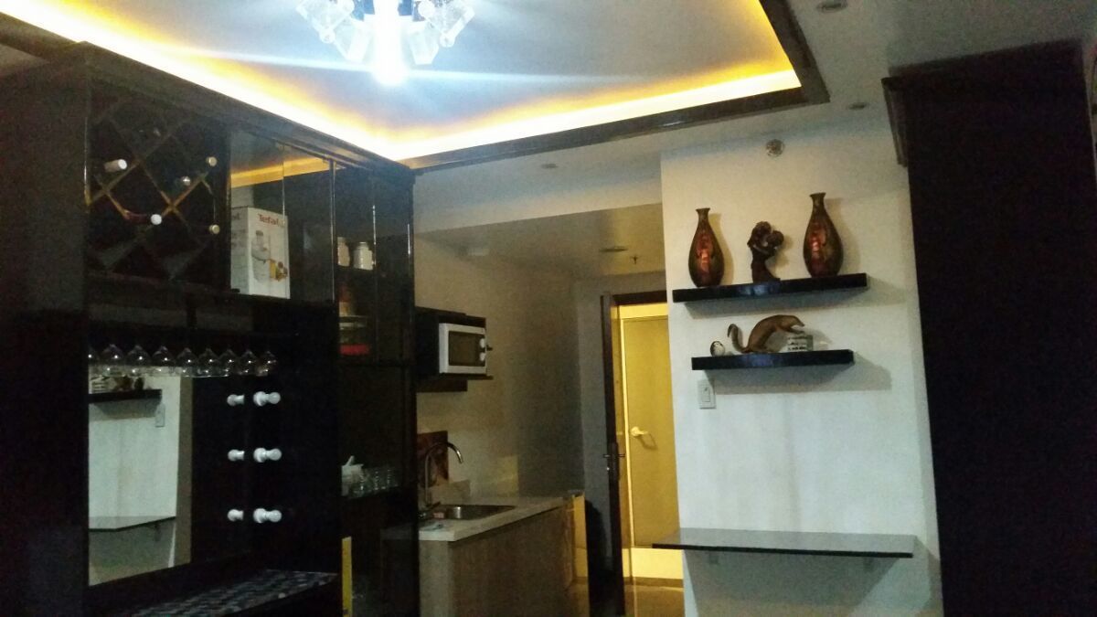 A compact kitchen with a microwave, a wine rack, and a small dining area.