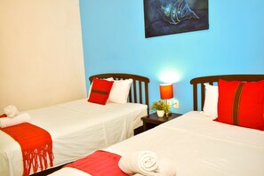 A hotel room with two single beds, each with white bedding and red accents, a nightstand with a lamp, and a framed artwork on the wall. - Balamku Hotel Cafe (Campeche)