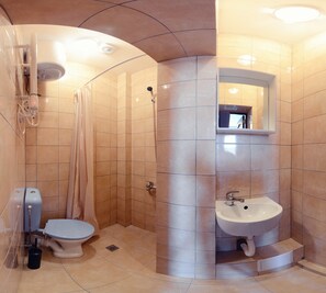 A compact bathroom with a toilet, shower, and sink. - easeApartments on Panagyurishte str. (Sofia)