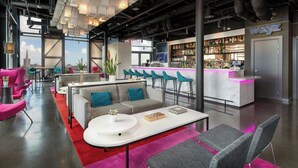 Un área de bar moderna con un letrero de neón, una barra y una variedad de botellas.