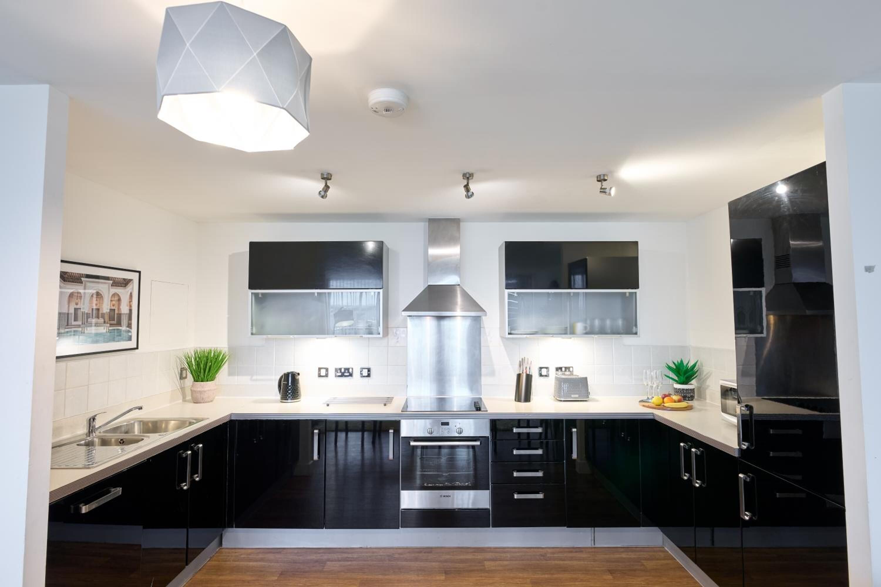 A modern kitchen with black cabinets, stainless steel appliances, and a central island.