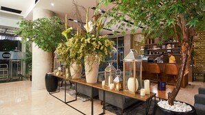A lobby with a reception desk, seating area, and decorative plants.