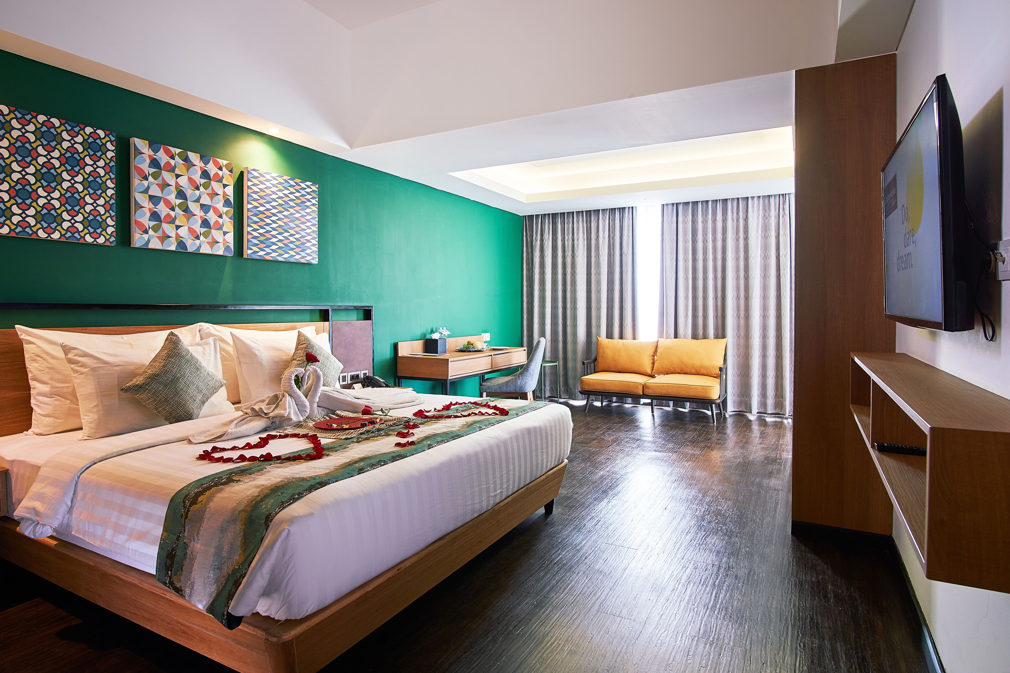 Una habitación de hotel con una cama grande, un escritorio, una silla y un televisor.