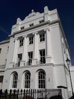 Un edificio blanco con un letrero que dice 'HOTEL' en la parte superior.