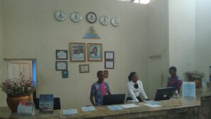 Un comptoir d’accueil orné de cadres contenant des certificats et une horloge placée au-dessus.