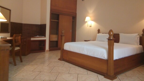 Une chambre d’hôtel équipée d’un lit, d’un bureau, d’une chaise et d’une armoire.