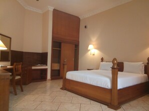 A hotel room with a bed, desk, chair, and wardrobe. - Asaa Pyramid Hotel (Kaduna)