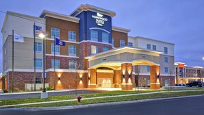 A modern hotel with a prominent "Homewood Suites" sign, featuring a brick facade, multiple windows, and a well-lit entrance. - Homewood Suites by Hilton Detroit (Warren)