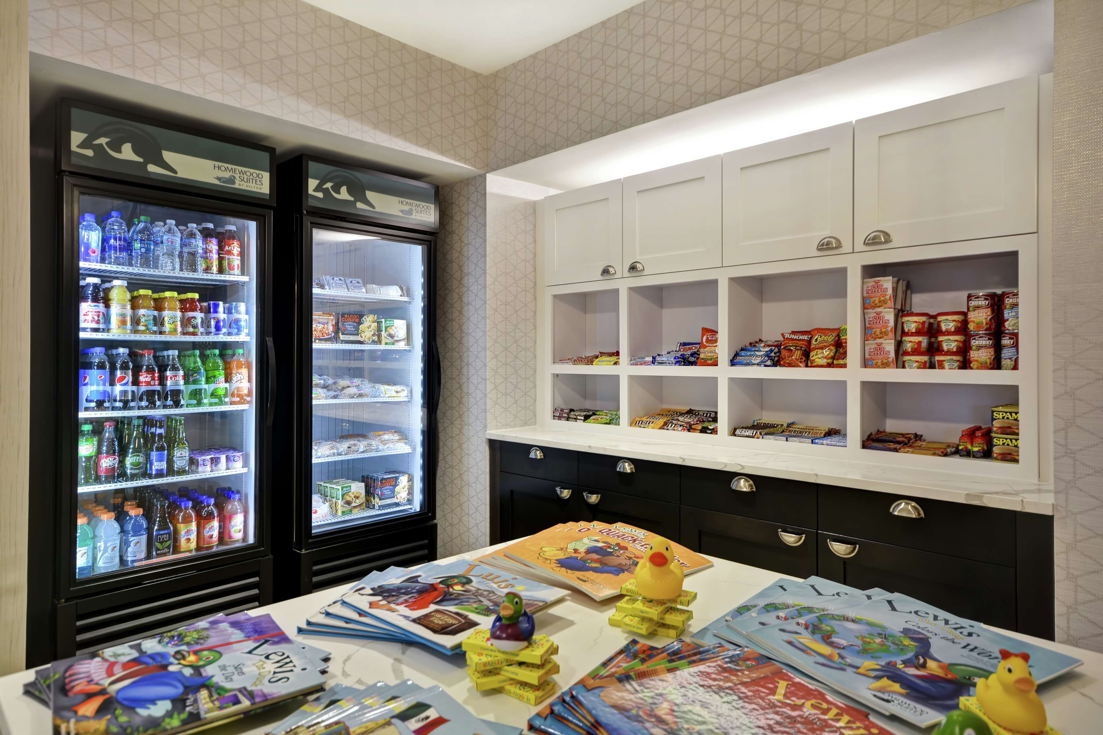 Ein Hotelzimmer mit Minibar, Kinderspielecke sowie einer Auswahl an Snacks und Getränken.