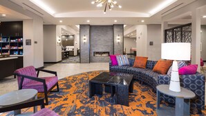 Eine moderne Lobby mit Kamin, Sitzgruppe und Bar.