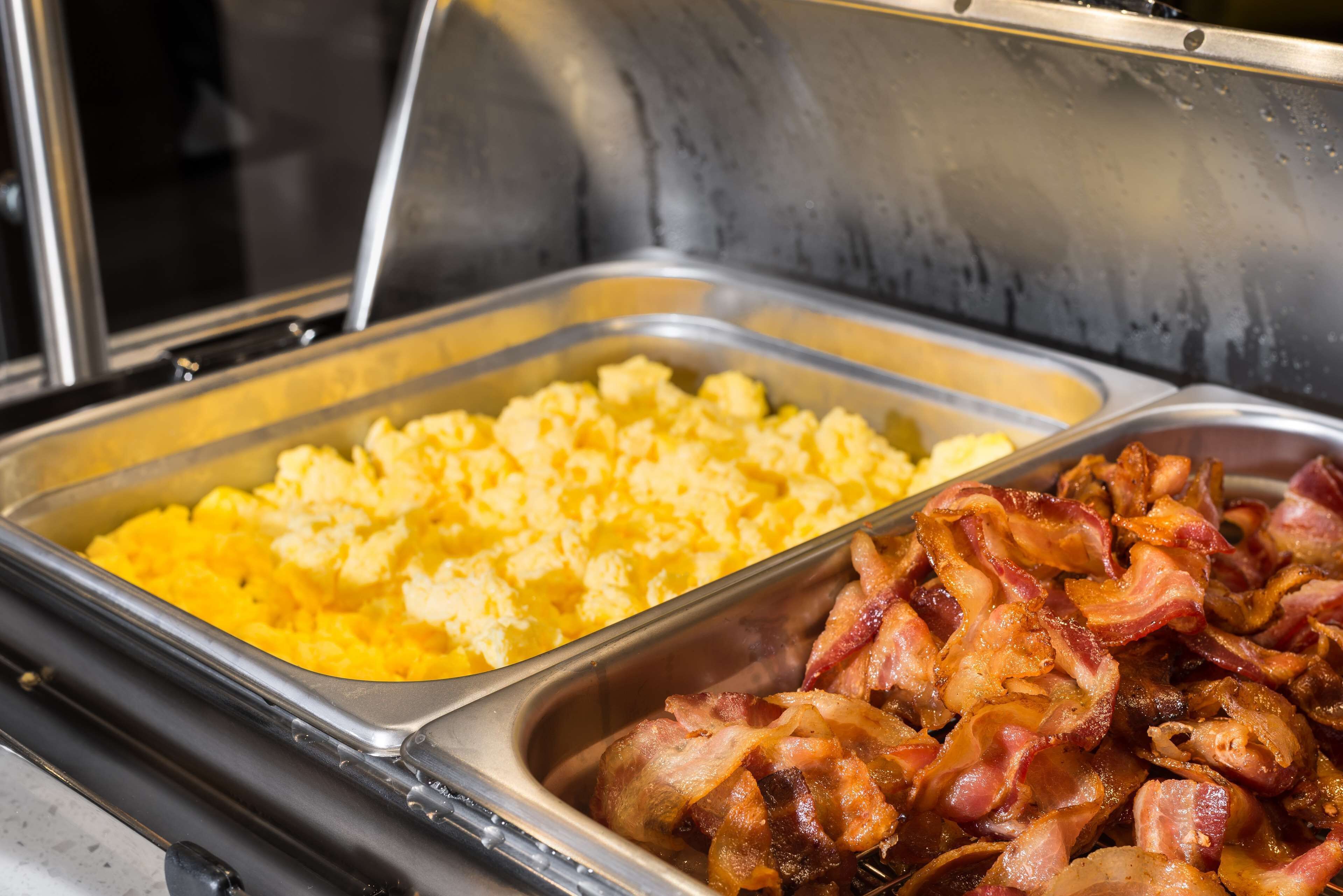 A buffet with scrambled eggs and bacon.