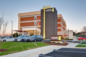 Un moderno edificio de hotel con un letrero que dice "HOME 2 Suites by Hilton".