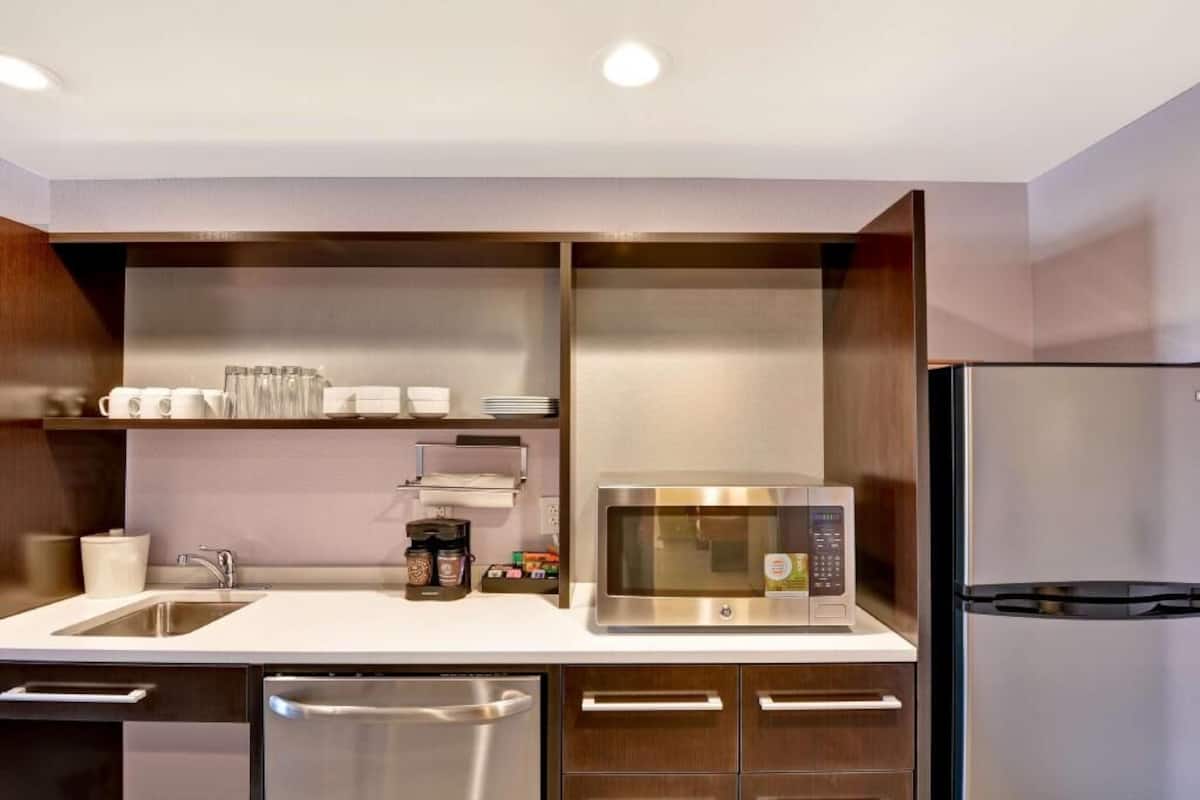 A modern kitchen with a stainless steel refrigerator, microwave, and dishwasher.
