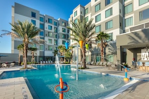 Alberca al aire libre, sombrillas en la alberca y camastros