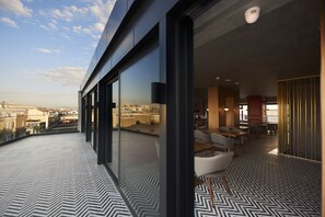 Un interior moderno con amplios ventanales, un suelo estampado y vistas a la ciudad.