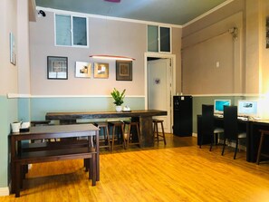 A modern kitchen with wooden flooring, a bar area, and two computers. - Melrose Hostel (Los Angeles)