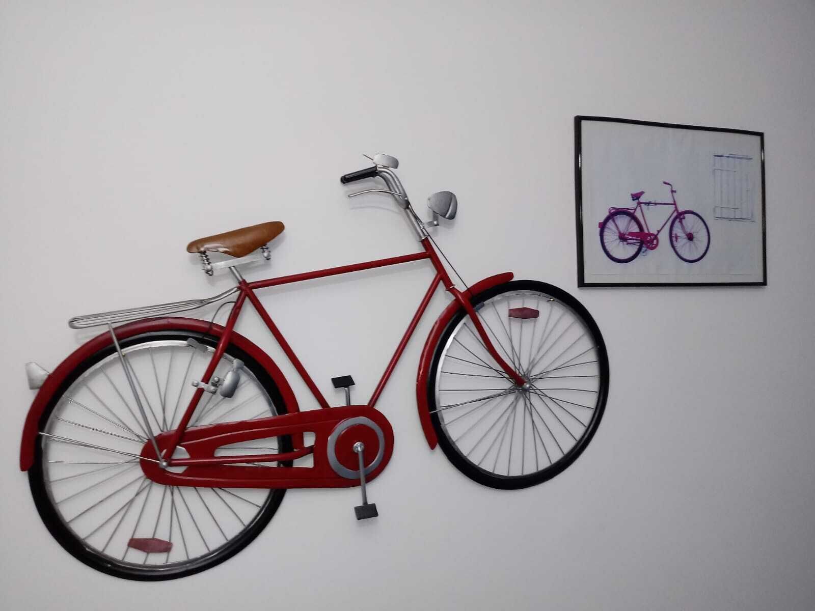 A red bicycle mounted on a white wall.
