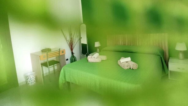 Quarto com uma cama, uma escrivaninha e uma cadeira.