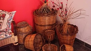Cestos de vime e um vaso de planta em frente a uma parede vermelha.