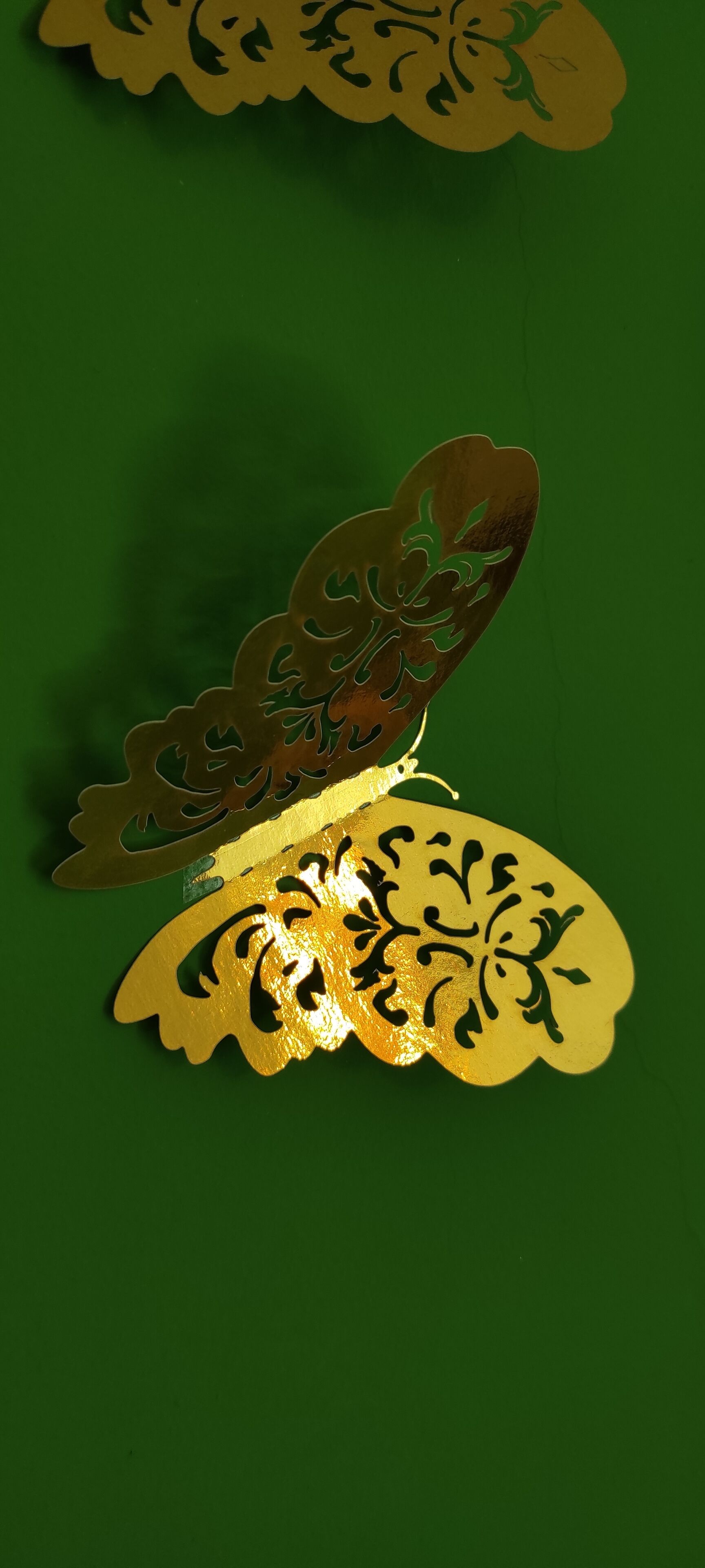 Een decoratief bladgoud patroon op een groene achtergrond.