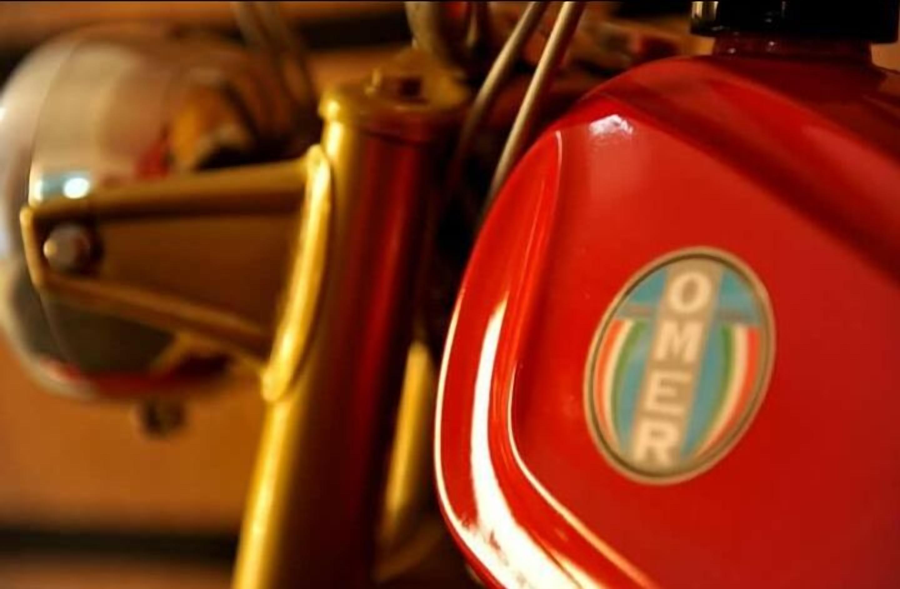 A close-up of a red motorcycle with a visible emblem.