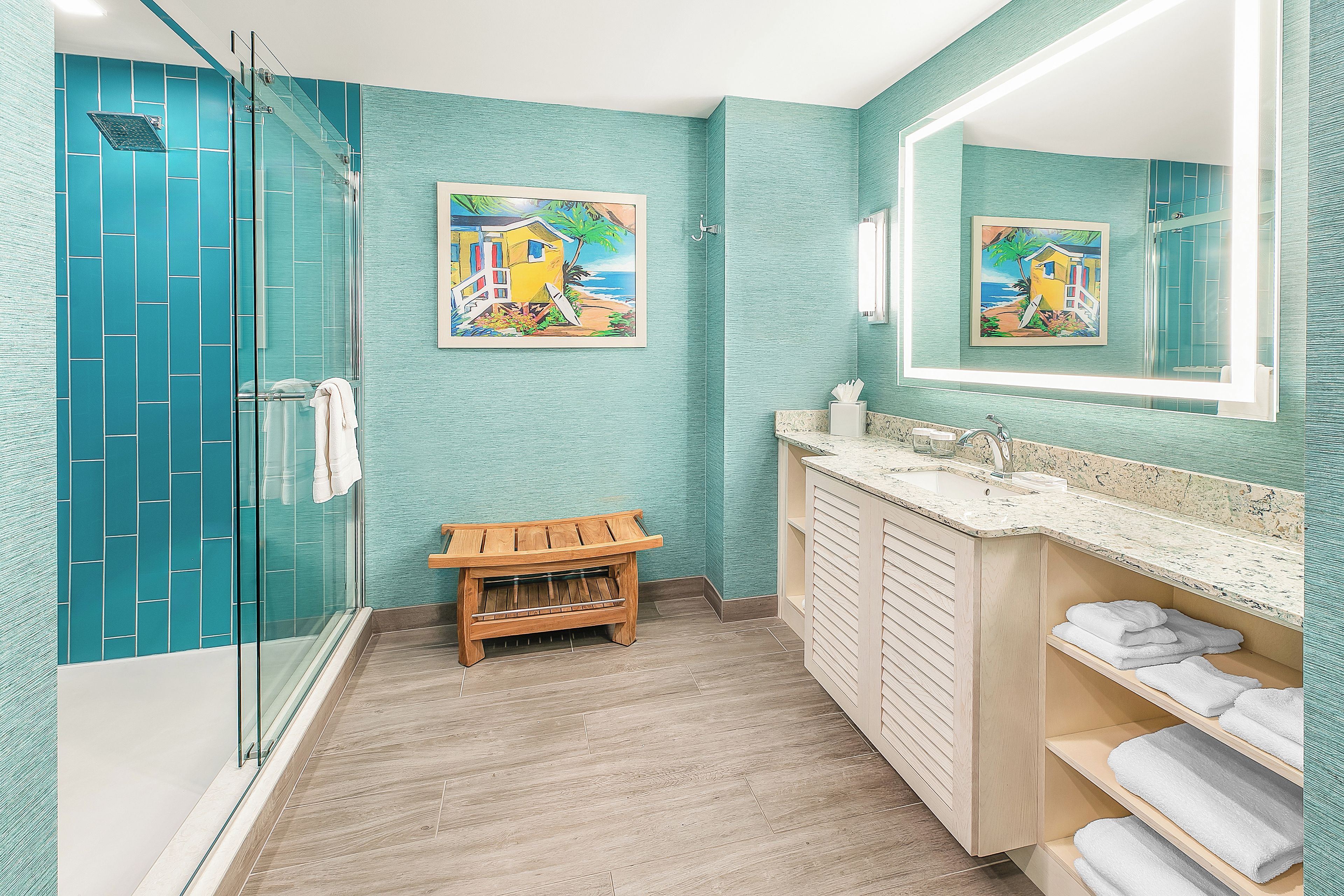 A bathroom with a glass shower enclosure, wooden vanity, and a large mirror.