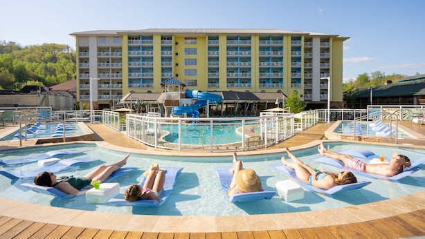 A pool area with multiple lounge chairs and a water slide.