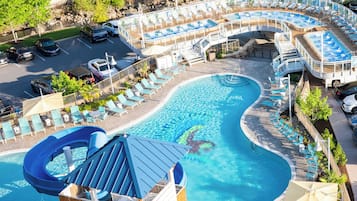 A pool area with multiple swimming pools, lounge chairs, and a water slide.