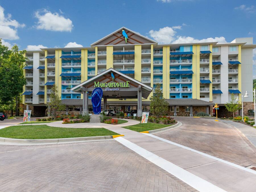 A multi-story hotel with a central entrance, balconies, and a sign reading "Margaritaville Resort".
