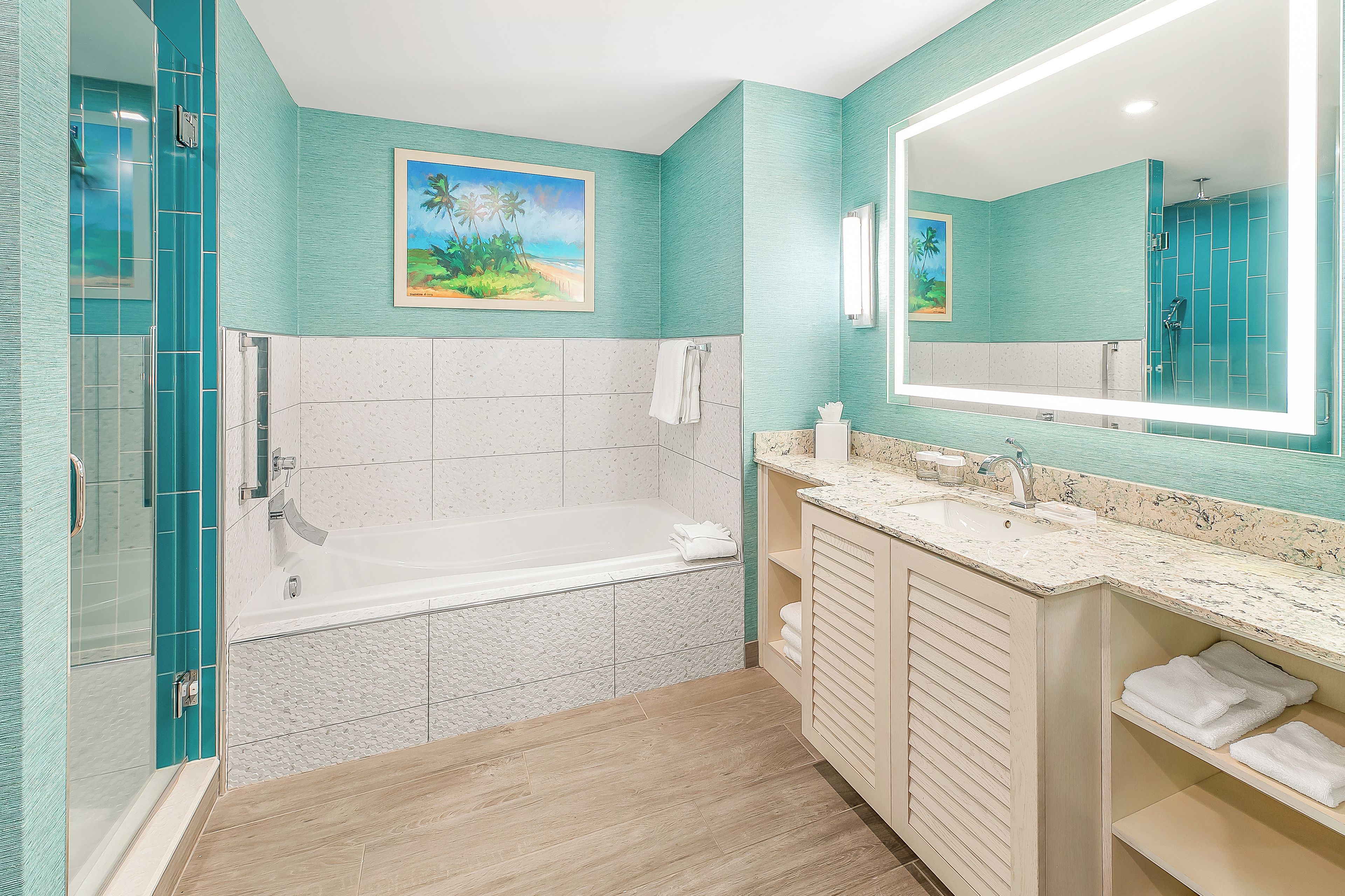 A bathroom with a bathtub, a shower, a vanity with a sink, and a large mirror.