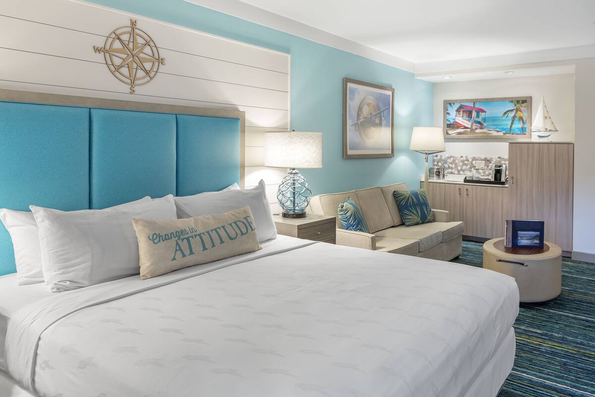 Une chambre d’hôtel avec un grand lit, un canapé, un bureau et une armoire.