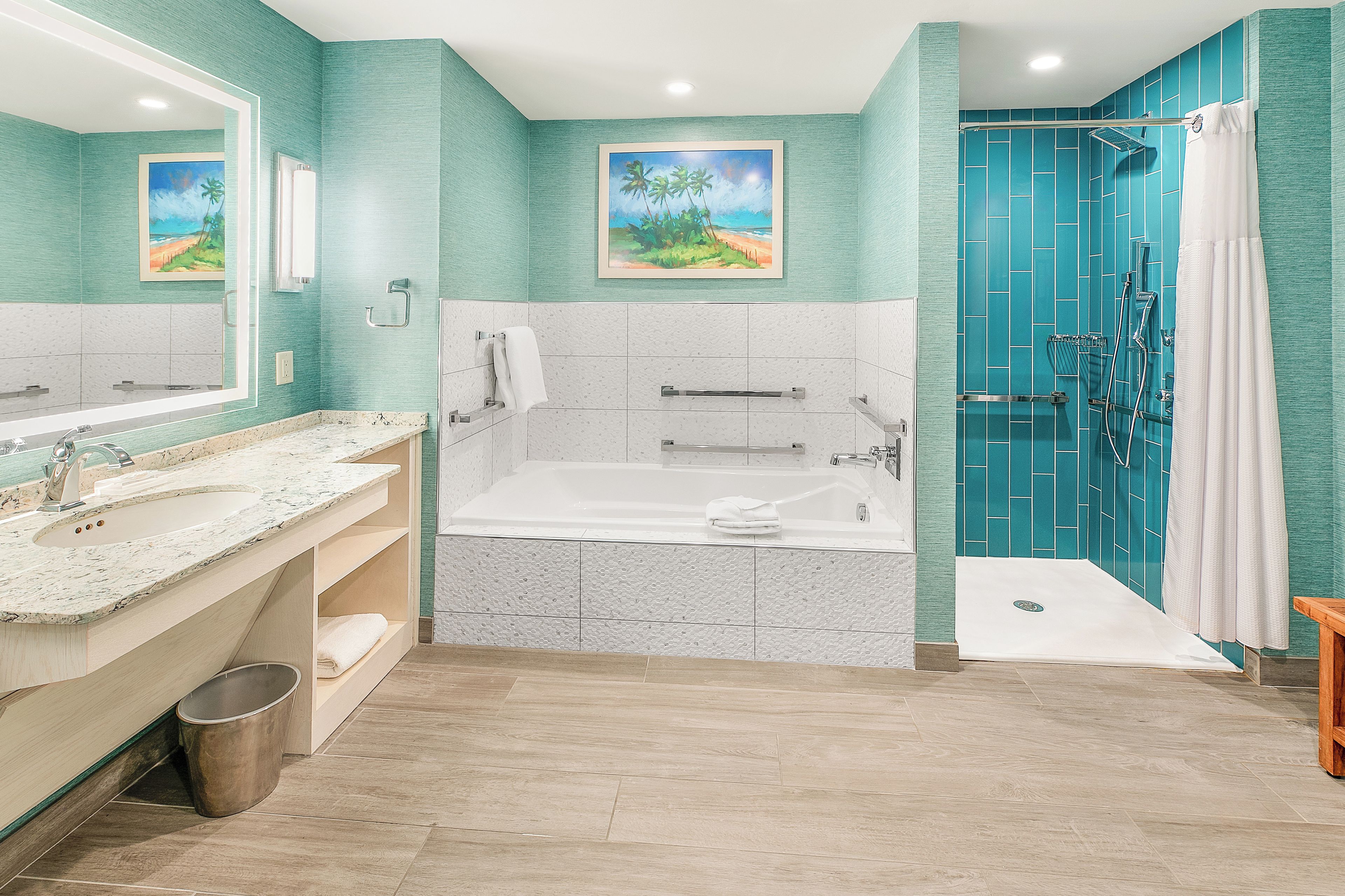 A bathroom with a bathtub, two sinks, a shower, and a toilet.