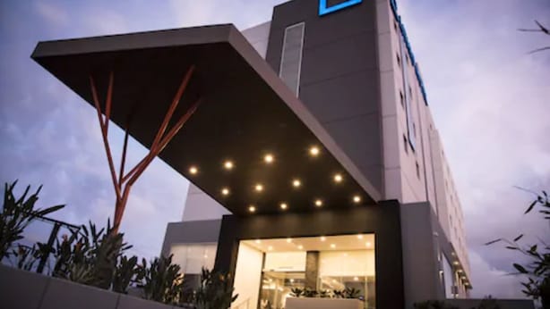 A modern hotel with a unique architectural design, featuring a prominent overhang and a large entrance. - Lithio Hotel (Veracruz)