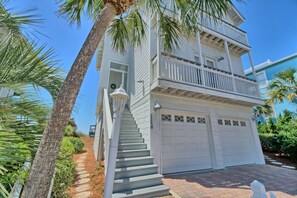 A two-story house with a front porch, a garage, and a balcony.