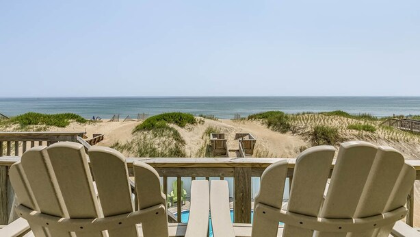 A beach view with two Adirondack chairs facing a wooden deck and a pool. - Pebble Beach | Oceanfront | Dog Friendly, Private Pool, Hot Tub | Nags Head (Nags Head)