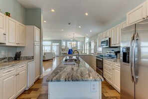 Kitchen features a central island with a sink and stainless steel appliances.