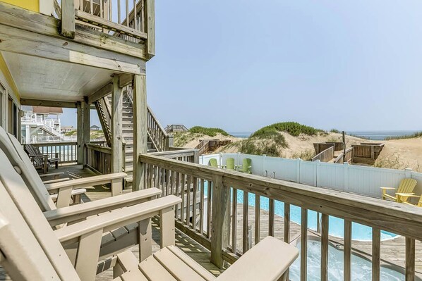 Relax on the deck with lounge chairs and enjoy the view of the beach.