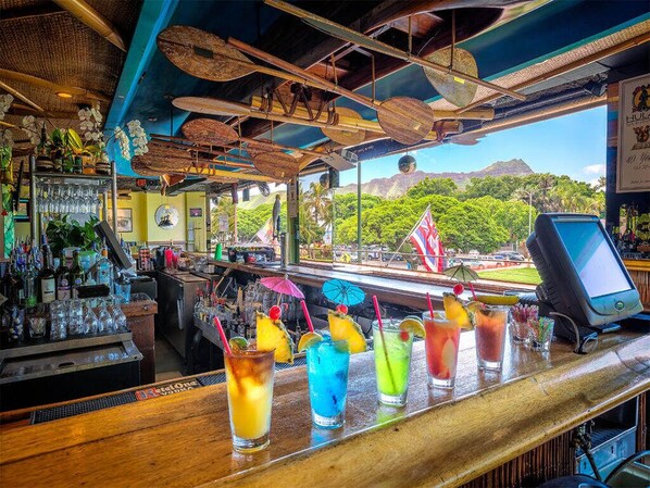 A bar with a view of a mountain and lush greenery.