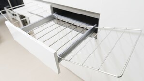A modern kitchen with a built-in stainless steel drying rack.