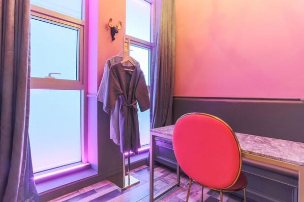 A room with a large window, a red chair, and a robe hanging on a rack. - H Avenue Hotel Kondae (Seoul)