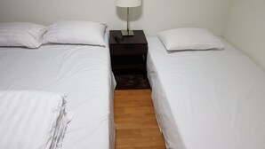 A twin room with two beds, a nightstand, and a lamp. - Galaxy Gangnam 2 (Seoul)