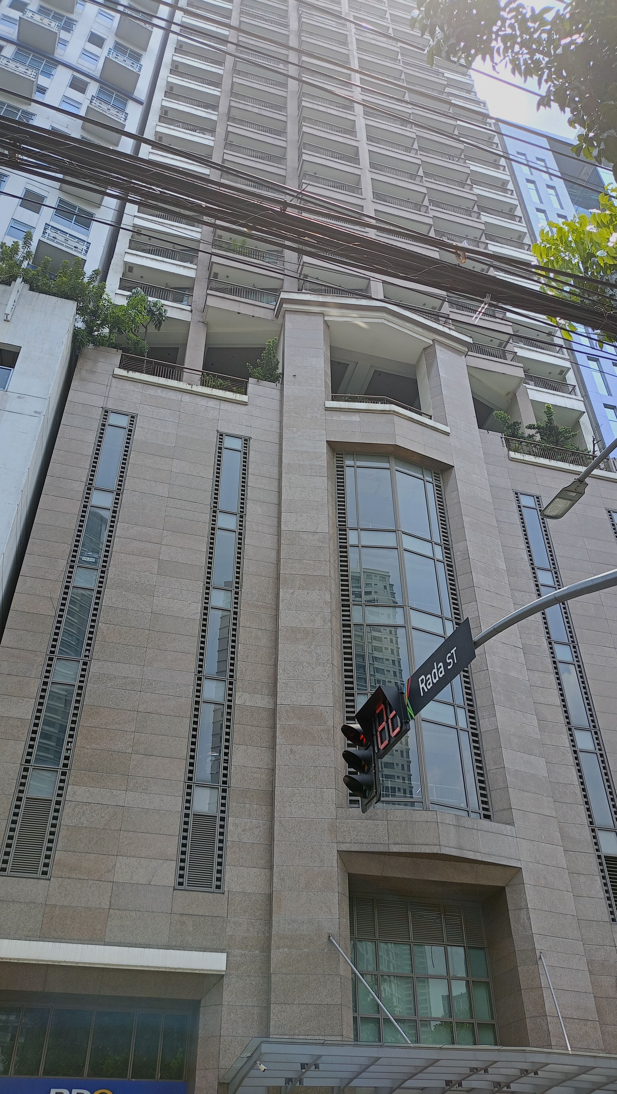 A multi-story building with large windows and a traffic light.