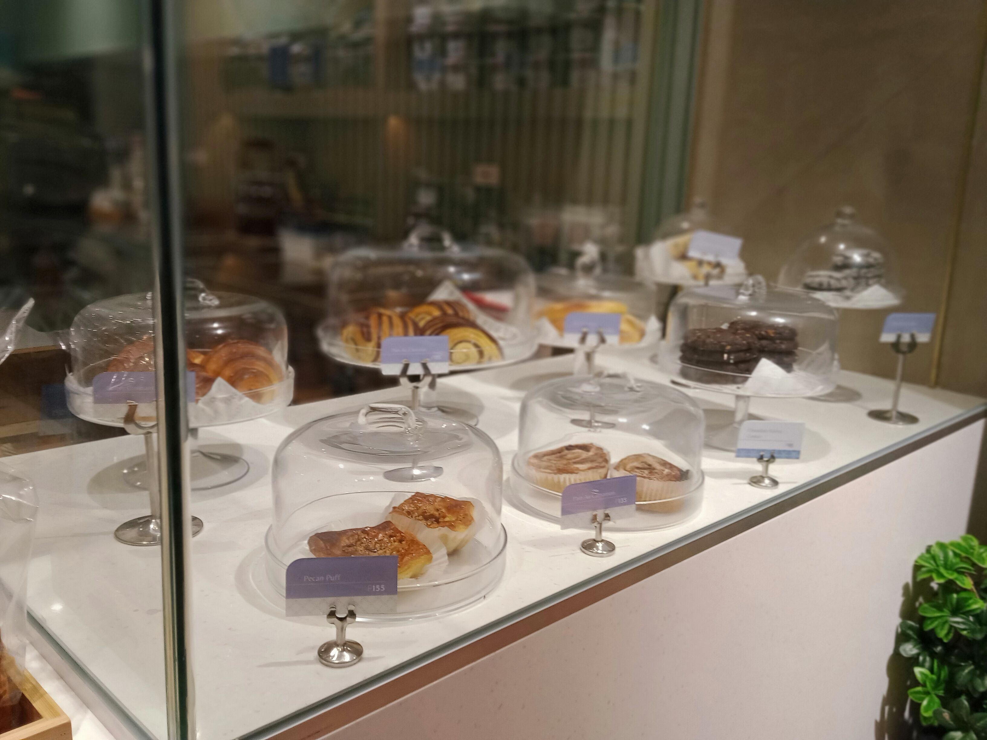 A display of various pastries and desserts in a bakery setting.