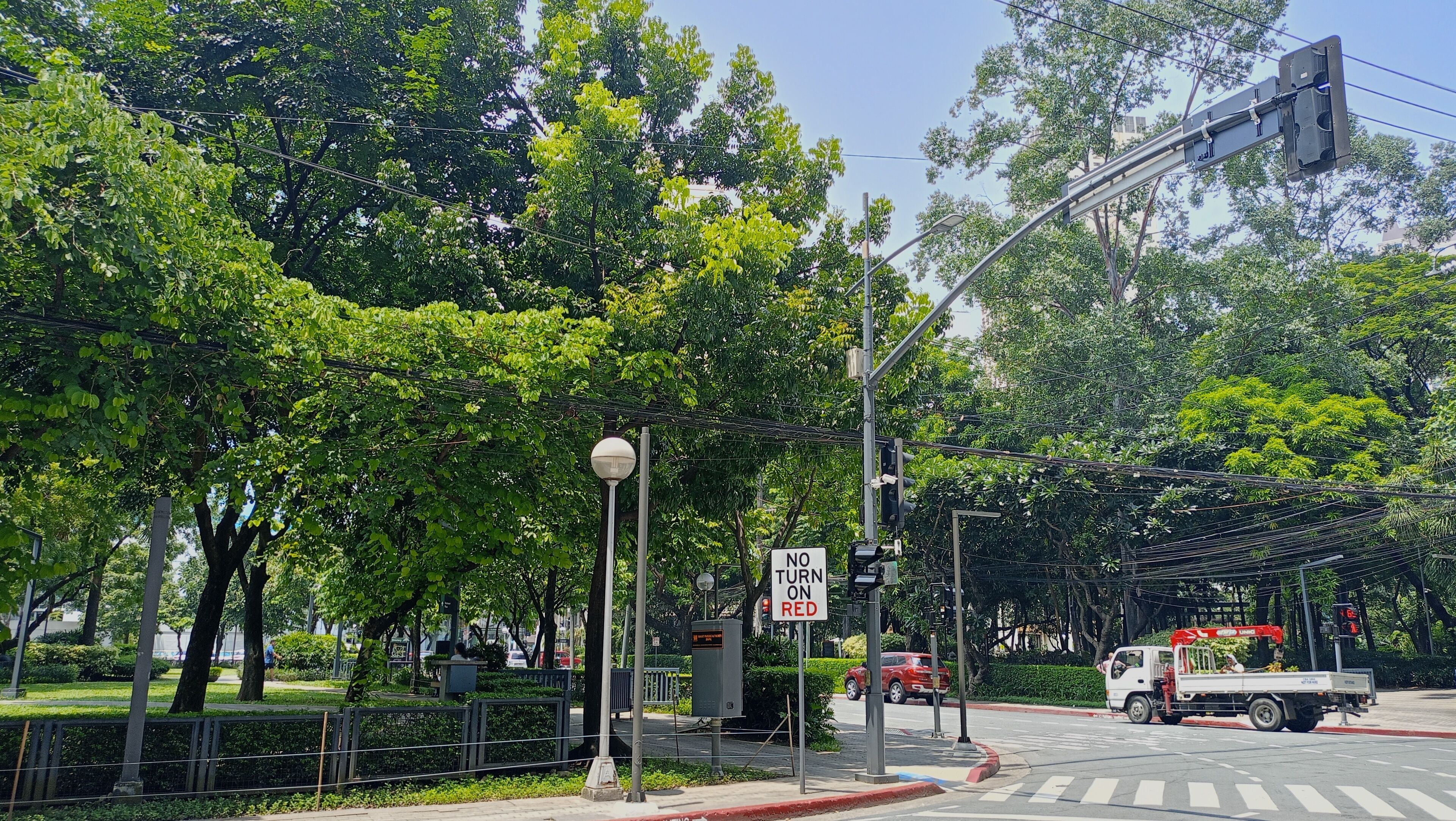 A street intersection with traffic lights, a no turn on red sign, and a utility truck.