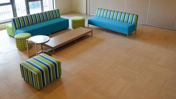 Un salon moderne avec un canapé bleu, une table basse en bois et des poufs à rayures.