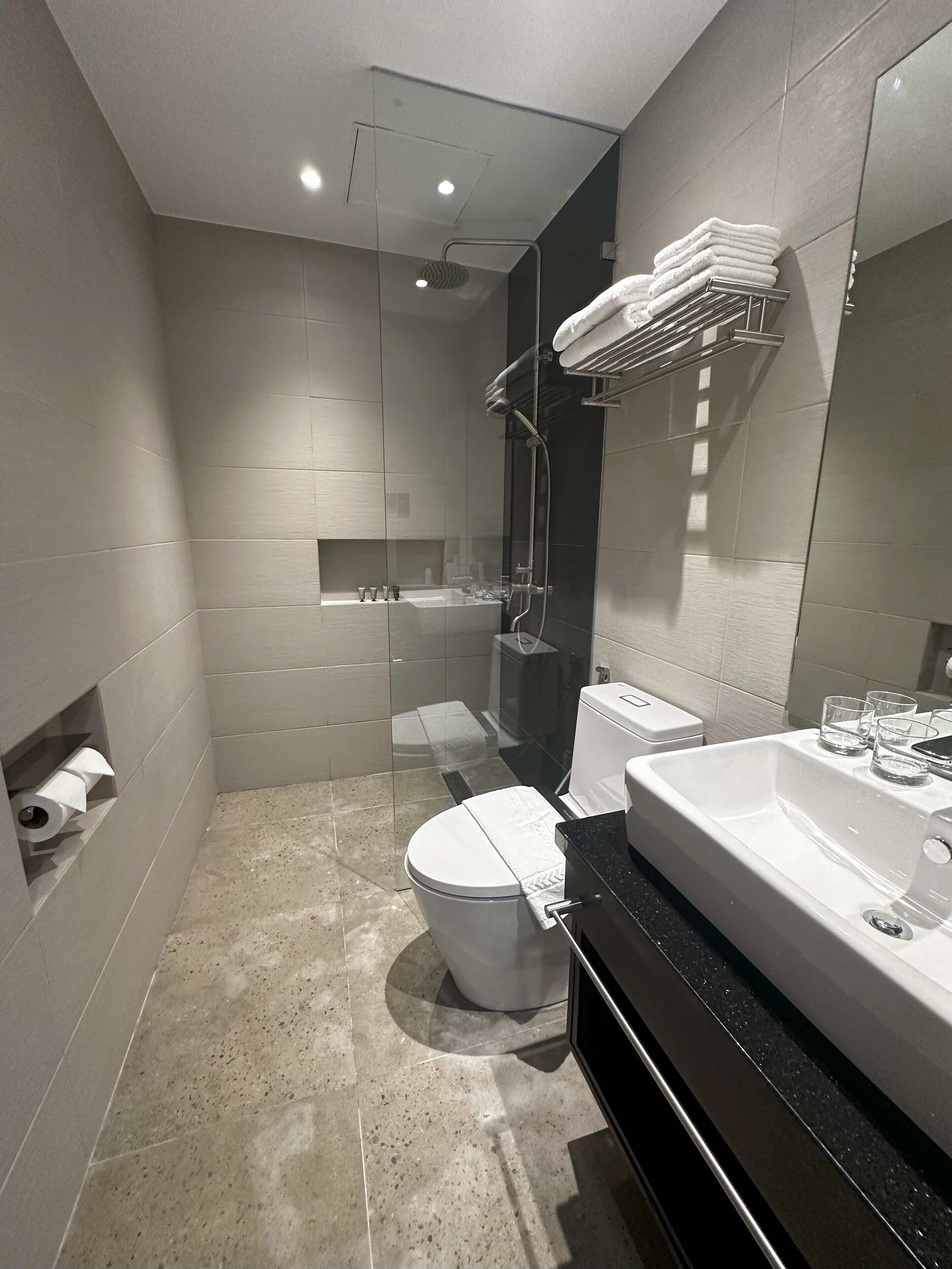 A modern bathroom with a toilet, sink, and shower.