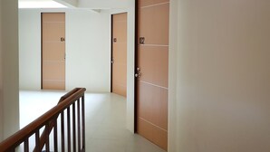 Un pasillo con puertas de madera, numeradas 102 y 104, que da a las habitaciones.