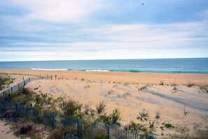 A beach with a wooden fence and sparse vegetation. - Bright, colorful 3 bedroom oceanfront townhouse with WiFi, fun decor, and two decks with fabulous ocean views located midtown and only steps to the beach! (Ocean City)