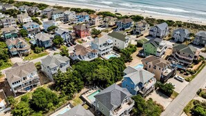 Un quartier résidentiel situé sur la côte, avec des maisons, une plage et une vue dégagée sur l’océan.